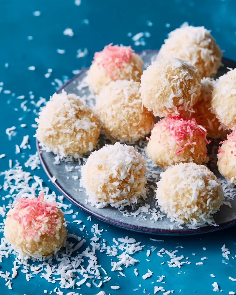 Coconut Cake Snowballs 3 A close-up shot of a baker gently rolling a perfectly formed Coconut Cake Snowball in shredded coconut.